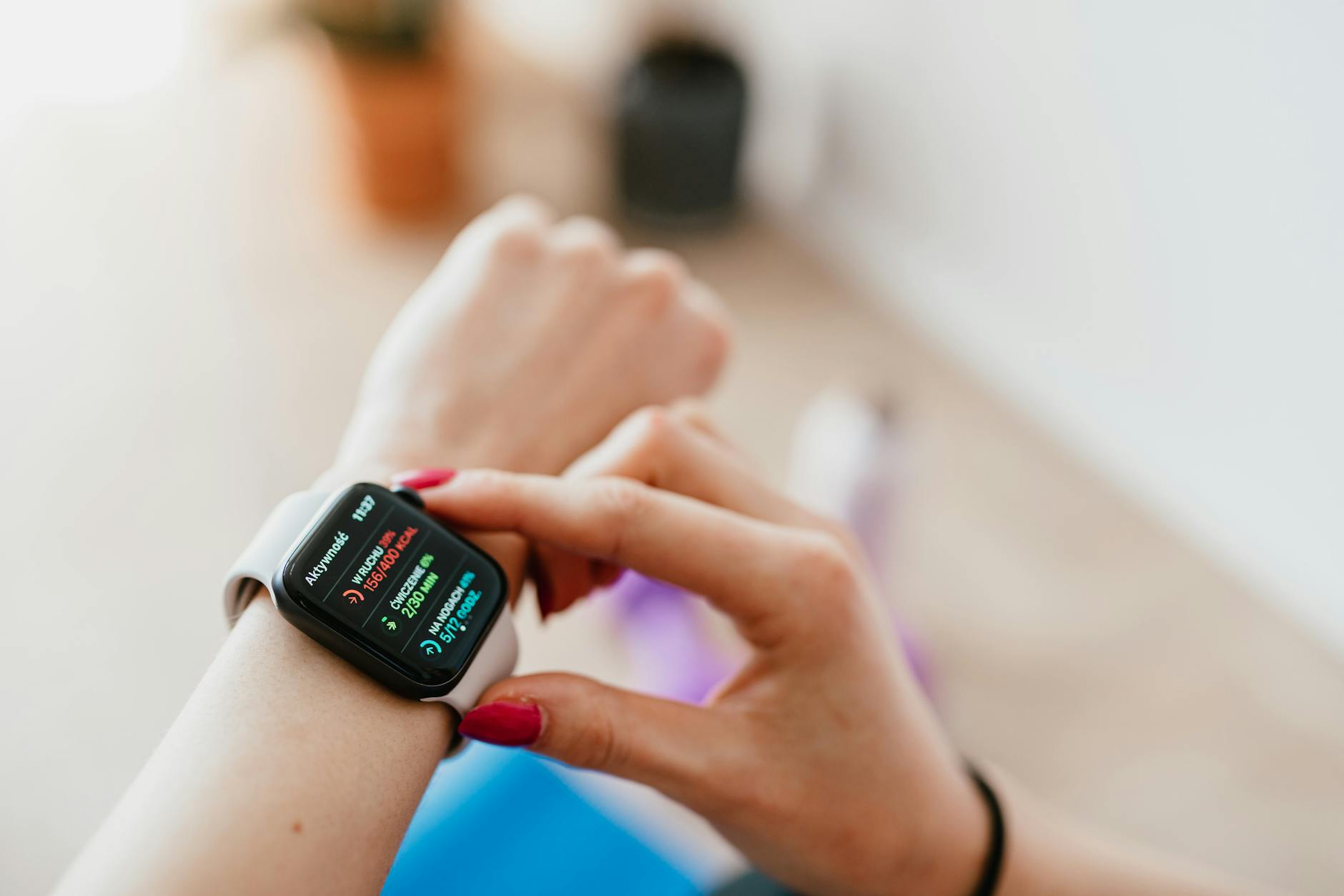 faceless woman checking smartwatch and sitting on mat