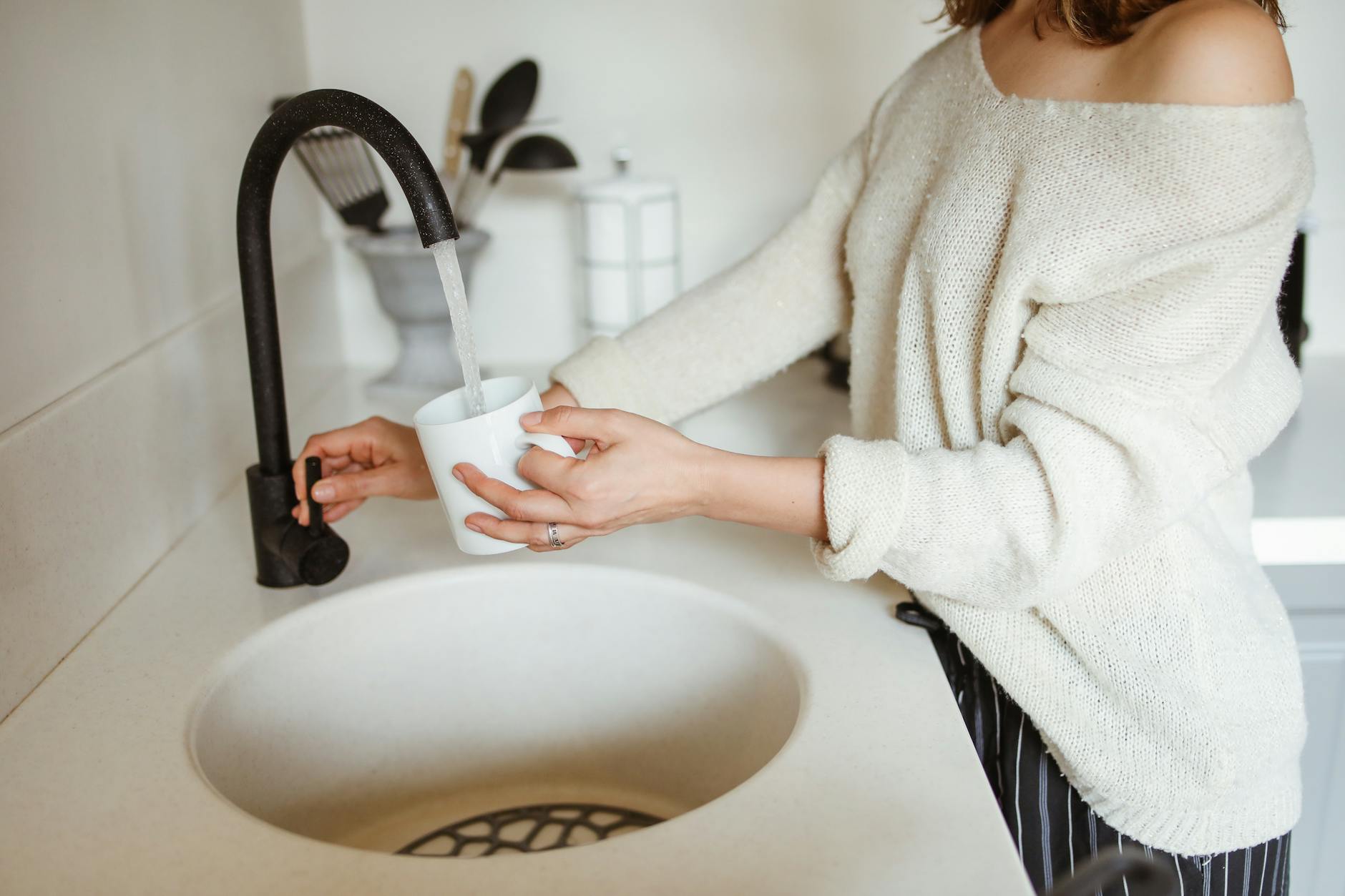 woman pouring water to cup
